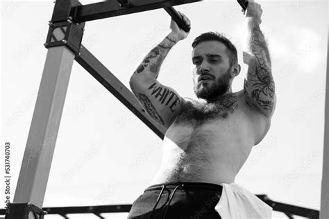 Muscular Bodybuilder Handsome Man With Naked Torso Trains Triceps In A