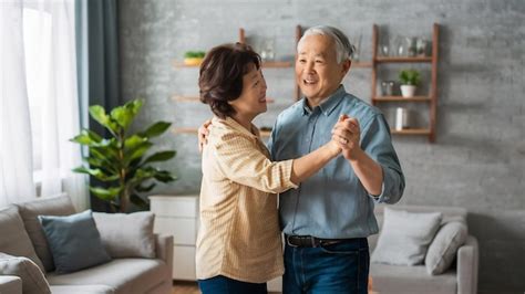 Una pareja de ancianos asiáticos bailando juntos mientras escuchan