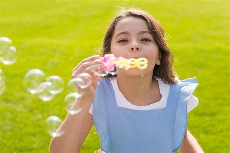 Coup Moyen Fille Faisant Des Bulles De Savon Photo Gratuite