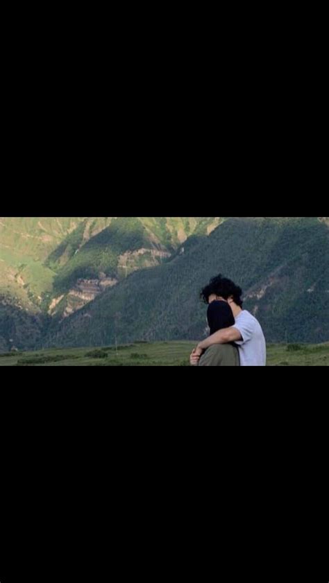 A Man Sitting On Top Of A Lush Green Hillside