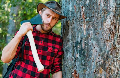 Premium Photo | Lumberjack worker standing in the forest with axe ...