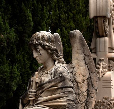 Una estatua de un ángel con una cruz Foto Premium