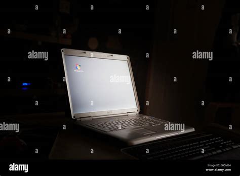 A Dell Laptop Computer In A Darkened Room With Windows Vista Screen