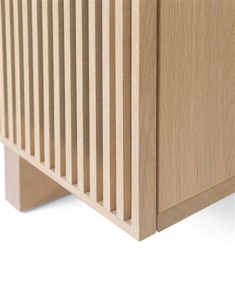 A Close Up View Of A Wooden Cabinet With Vertical Slats On The Front