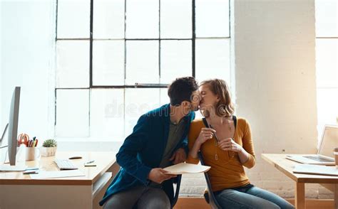 More Than An Office Romance Young Couple Kissing While Working