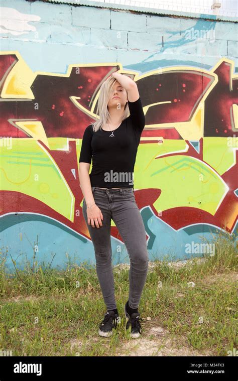Belle Fille Blonde En Jeans Se Leva D Un Mur De Graffiti Photo Stock