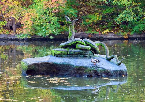 Kunstig slange på sten i dam center i efteråret park Stock foto