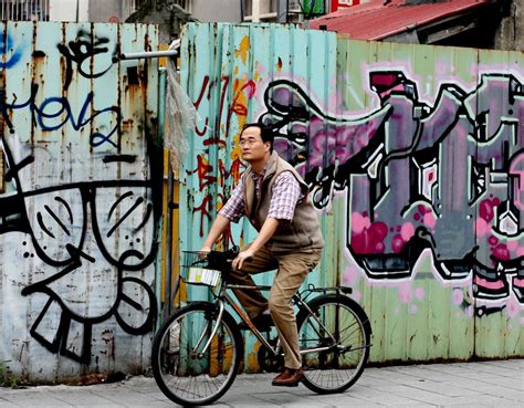 Man Riding A Bike In Front Of A Wall Covered In Graffiti Gems Photos And Videos