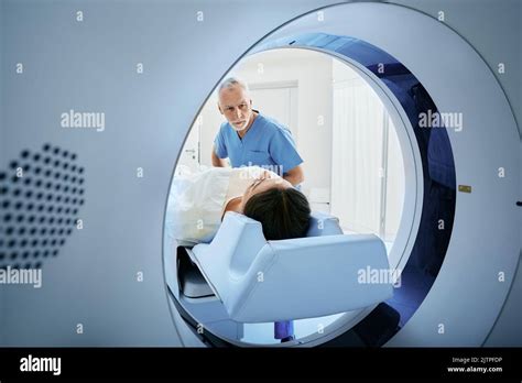 Ct Scan Technologist Overlooking Patient In Computed Tomography Scanner