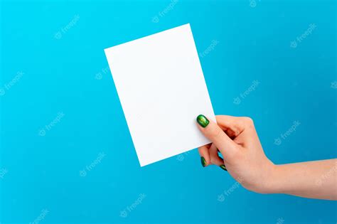 Premium Photo Woman Hand Holding Blank Card On Blue Wall