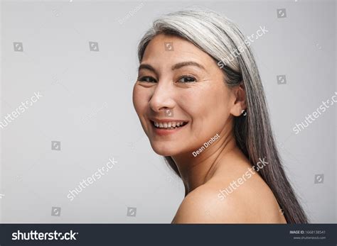 Beauty Portrait Of An Attractive Smiling Mature Topless Woman With Long Gray Hair Standing