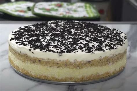 A Cake With White Frosting And Black Sprinkles Sitting On A Counter