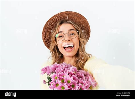Happy Blonde Girl Wearing Stylish Hat Posing With Bouquet Of Flowers Making Selfie White Studio