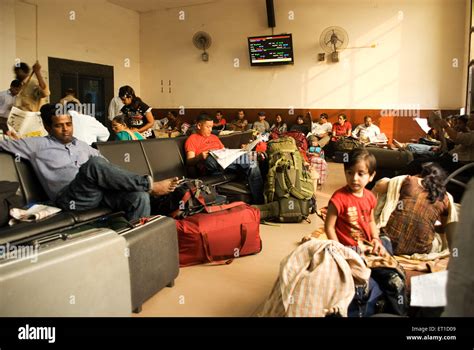 People sitting in waiting room of railway station ; New Delhi ; India ...