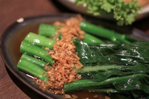 Kale Fried In Oyster Sauce With Garlic On Wooden Table Chinese Kailan