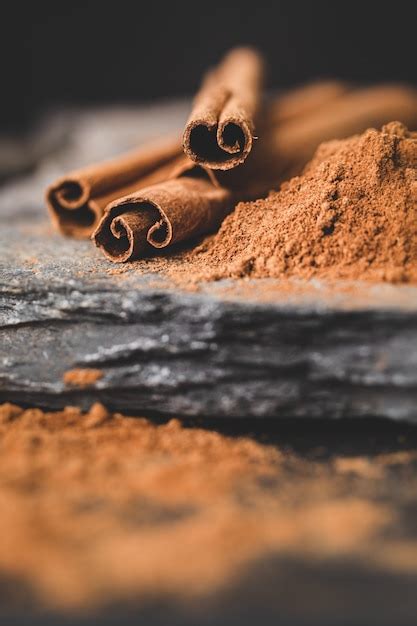 Premium Photo Cinnamon Stick And Powder On Black With Stones