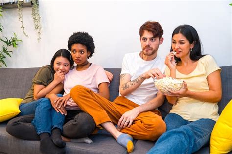 Premium Photo Friends Eating Pop Corn While Watching A Thriller Film