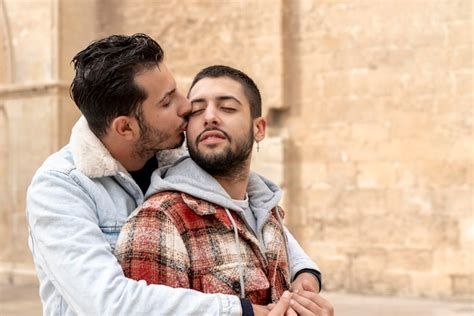 Gros plan sur un jeune couple gay aimant se câliner dans la rue Photo Premium