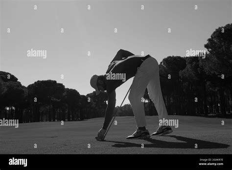 Golf Player Placing Ball On Tee Beautiful Sunrise On Golf Course