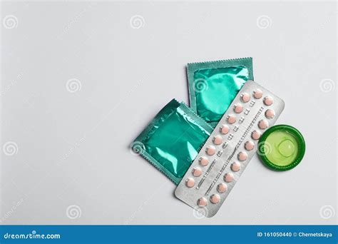 Condoms And Birth Control Pills On Light Grey Background Space For