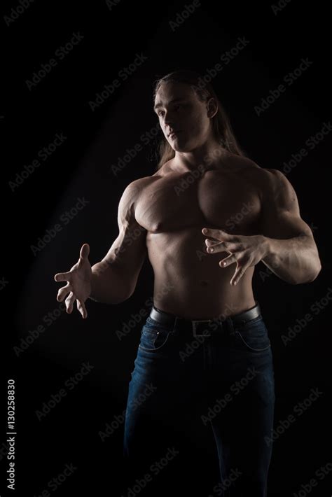 Naked Torso Male Bodybuilder Athlete With Long Blond Hair In Studio On A Black Background Stock