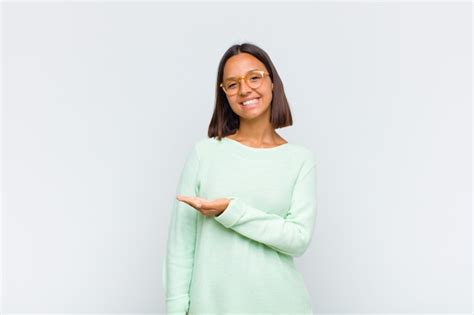 Mulher latina sorrindo alegremente se sentindo feliz e mostrando um conceito no espaço da cópia