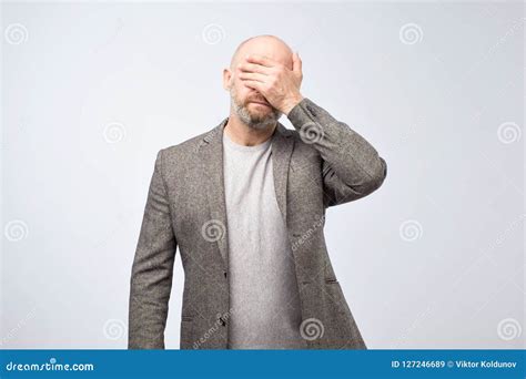 Portrait A Disappointed Mature Man Covering His Face With His Hand