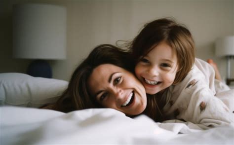 Una madre y su hijo están acostados en una cama y sonriendo Foto Premium