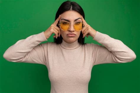 Chica caucásica bastante morena disgustada en gafas de sol pone los