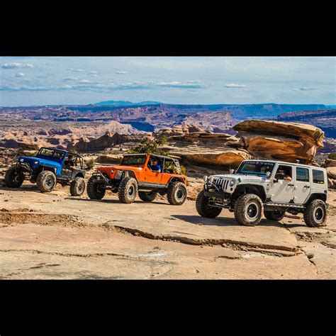 Four Jeeps Parked On The Side Of A Rocky Hill With Large Rocks In The