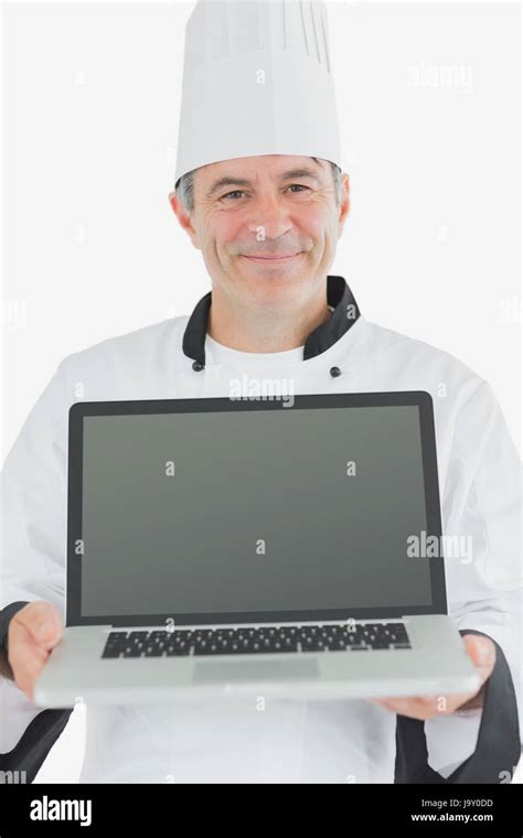 Portrait Of Happy Male Chef Presenting Laptop Against White Background