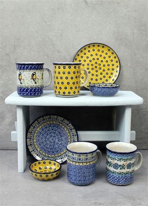 A White Table Topped With Lots Of Blue And Yellow Dishes Next To A