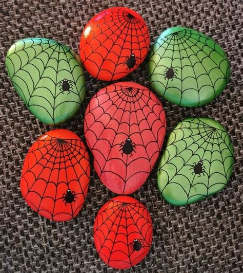 Six Painted Rocks With Spider Web Designs On Them