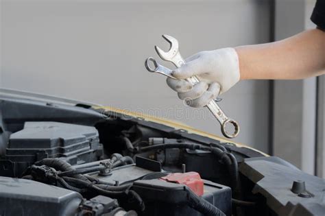 Auto Mechanic Holding A Wrench And Working On Car Broken Engine In