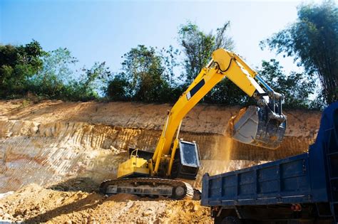 Escavadeira industrial e caminhão trabalhando no canteiro de obras para