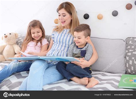 Nanny Reading Book To Little Children At Home Stock Photo By ©newafrica