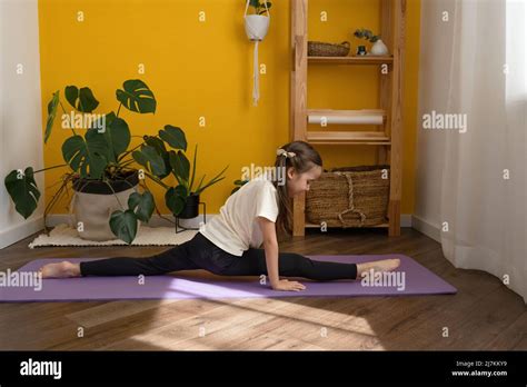 Full Body Of Focused Young Girl In Activewear Doing Front Splits Pose