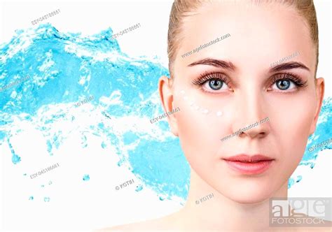 Sensual Woman With Cream Dots On Face In Blue Water Splash Stock Photo