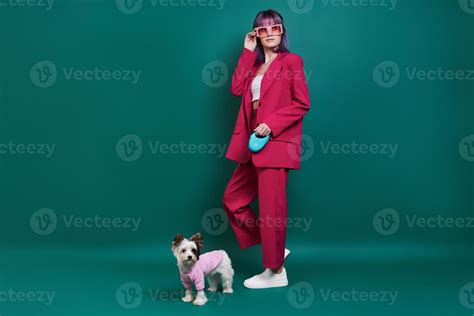 Glamourous young woman walking with little dog against green background 13575906 Stock Photo at ...