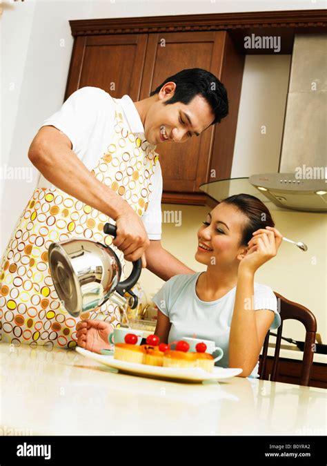 Husband Pouring Hot Drink For Wife Stock Photo Alamy
