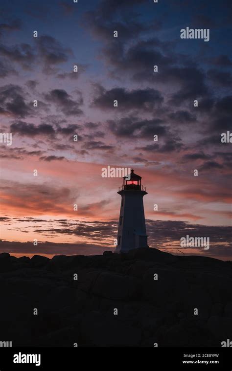 Silhouette Of Peggys Cove Lighthouse Located On Stony Coast Against