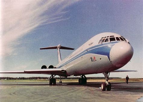 An Airplane Sitting On The Tarmac With People Standing Around It