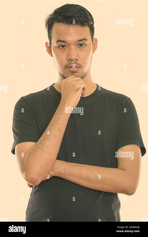 Studio Shot Of Young Asian Man Thinking Stock Photo Alamy