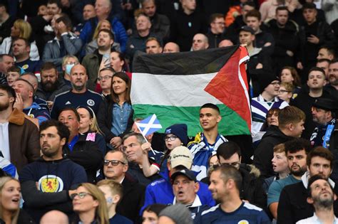 Football fans raise the Palestinian flag during a match between ...