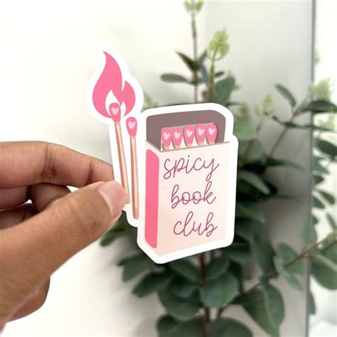 A Person Holding Up A Pink Sticker That Says Spicy Book Club With