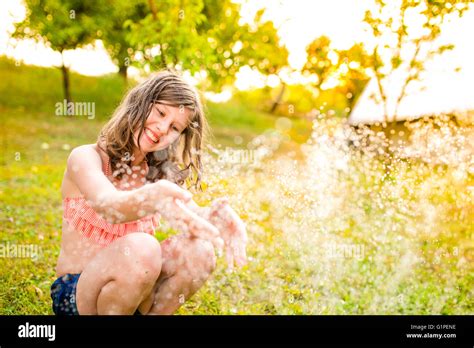 Mädchen im Bikini sitzen an den Sprinkler Sommergarten Stockfotografie Alamy