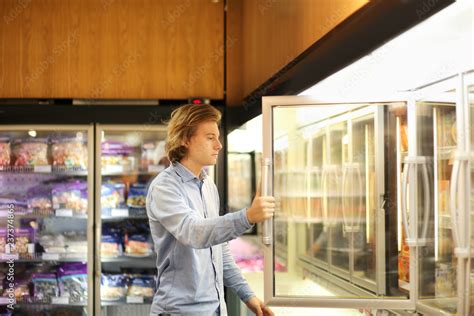 Man choosing frozen food from a supermarket freezer Stock Photo | Adobe ...