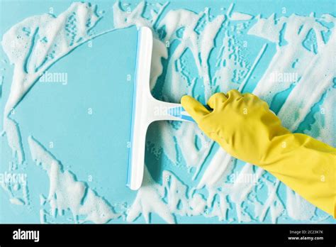 Hand In A Yellow Rubber Glove Washing Window With Squeegee And