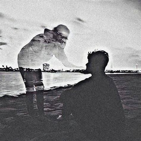 Black And White Photograph Of Two Men Sitting On The Beach One Looking