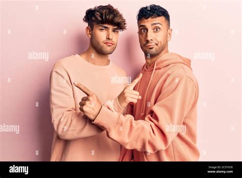 Jeune Gay Couple Portant Des V Tements D Contract S Pointant Des Deux C T S Avec Les Doigts